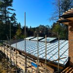 Standing seam zinc roof over an indoor swimming pool with angled ridge skylights