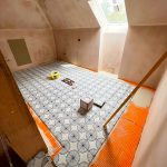 Ceramic floor tiling in progress for a second floor laundry room